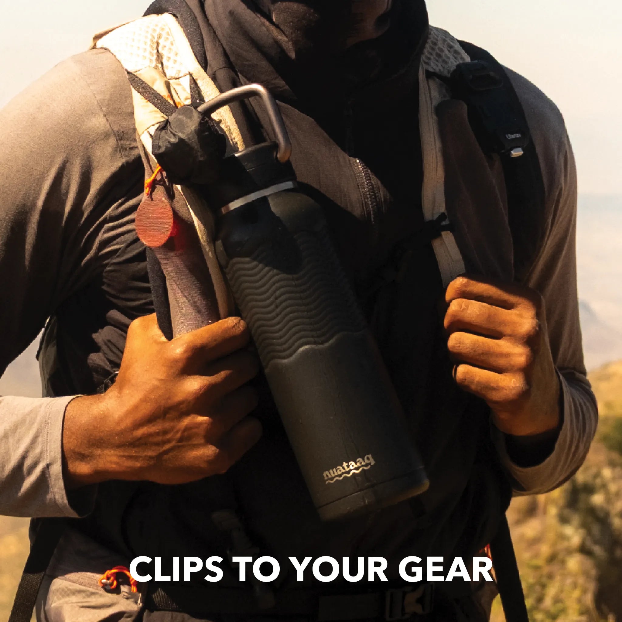 climber outdoors with carabiner bottle in obsidian clipped to front of backpack