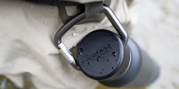 Black carabiner bottle attached to the waist belt of a fisherman